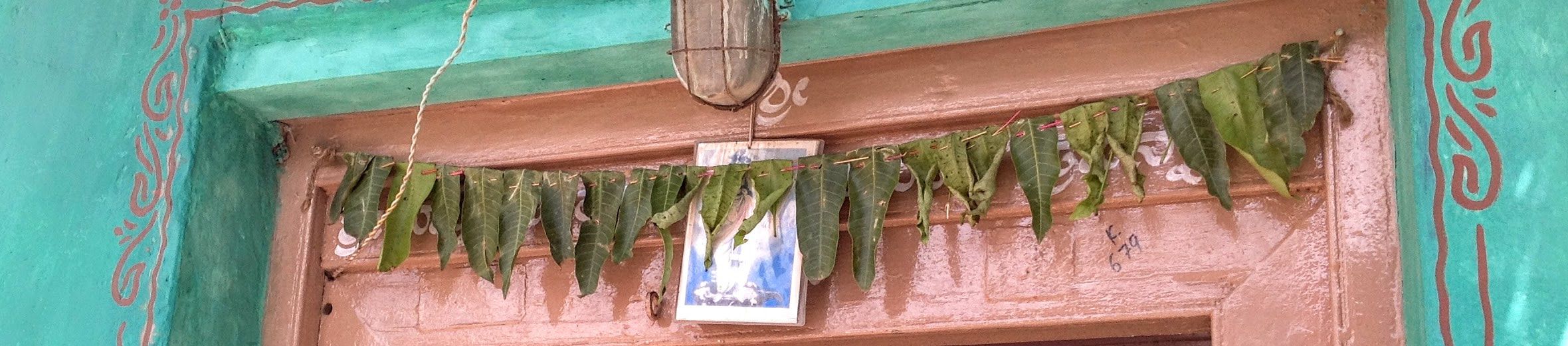 A simple, handmade, mango-leaf Torana, hanging over the doorway to our ancestral home